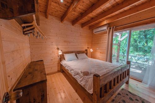 um quarto com uma cama num chalé de madeira em Zini House em Ein Zivan