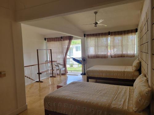 uma sala de estar com 2 camas e uma varanda em Casa Amarilla em Zihuatanejo
