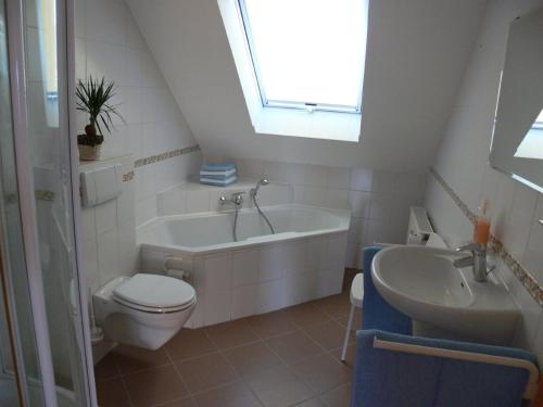 a bathroom with a tub and a toilet and a sink at Komfort Ferienwohnung II Wolfhagen in Wolfhagen