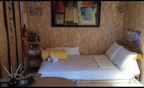 um pequeno quarto com uma cama branca num quarto em Wooden House at the Mountain-private em Paránimfoi