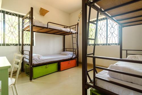 a room with bunk beds and a table and chairs at Tranquilo Arambol in Arambol