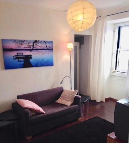 una sala de estar con sofá y una pintura en la pared en Flat in Bairro Alto, en Lisboa