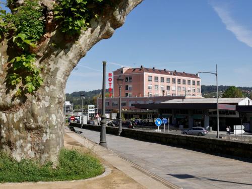 una calle de la ciudad con un edificio y un árbol en Hotel Eumesa, en Puentedeume