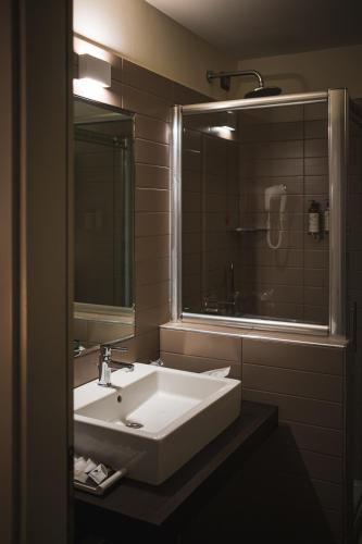a bathroom with a white sink and a mirror at Lake Hotel La Pieve in Pisogne