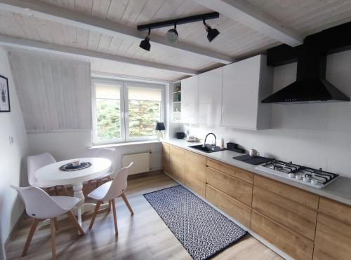 a kitchen with white cabinets and a table and chairs at Świętokrzyska Sielanka in Miedziana Góra