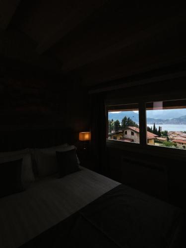 a bedroom with a bed and a window with a view at Lake Hotel La Pieve in Pisogne