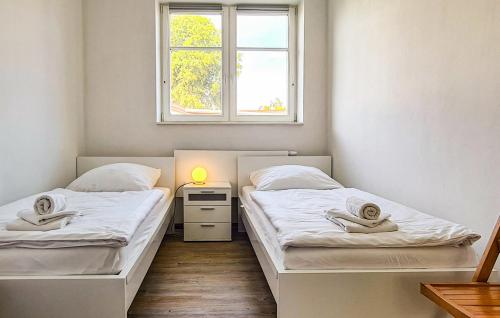 2 camas en una habitación pequeña con ventana en Ferienwohnung Wesenberg in Zirtow, en Wesenberg
