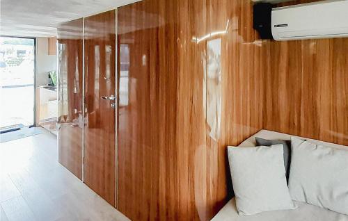 a bedroom with a wooden wall and a bed with a pillow at Pet Friendly Ship In Havelsee Ot Ktzkow With Sauna in Neuruppin