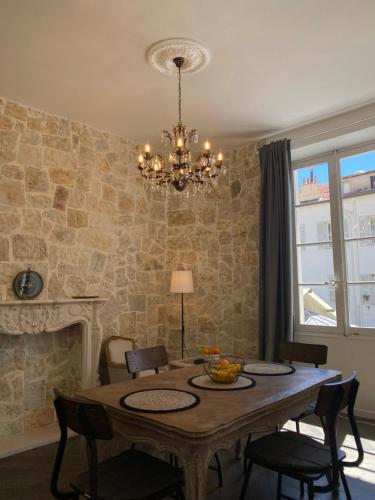 une salle à manger avec une table, des chaises et un lustre dans l'établissement HEART OF OLD TOWN - BEACH 150m & PALAIS DES FESTIVALS 600m, à Cannes