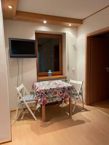 a room with a table and two chairs and a television at Apartment im Pfälzerwald in Lambrecht