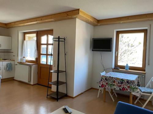 uma sala de estar com uma mesa e uma televisão na parede em Apartment mit Ausblick em Lambrecht