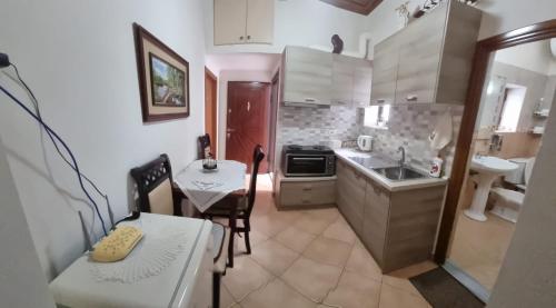 a small kitchen with a table and a sink at Romeo's Guest House in Berat