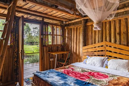 una camera da letto con letto in una camera in legno di Kalitusi Nature Resort a Fort Portal