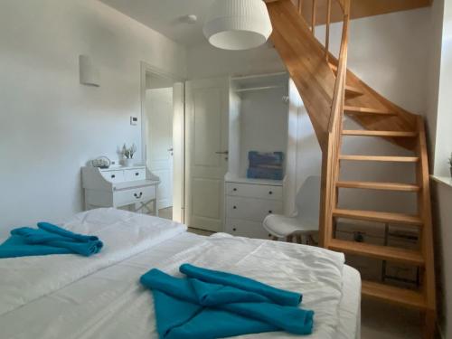 a bedroom with a staircase and a bed with blue pillows at Min Droom Usedom in Zirchow