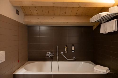 a bath tub in a bathroom with a shower at Lake Hotel La Pieve in Pisogne