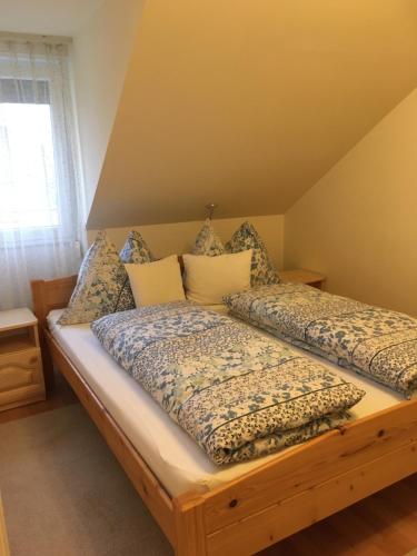 a bed with two pillows on it in a room at Jázmin Deluxe Apartman in Harkány