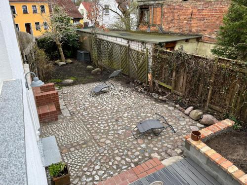 an outdoor patio with two umbrellas in a yard at Stadthaus Usedom in Usedom Town