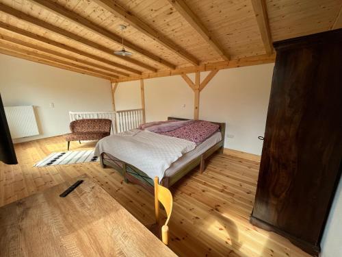 a bedroom with a bed and a chair in a room at Stadthaus Usedom in Usedom Town