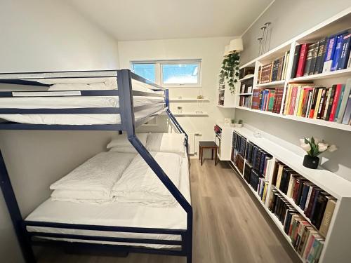 a bunk bed in a room with bookshelves at Modern 2 bedroom apartment in Kópavogur in Reykjavík