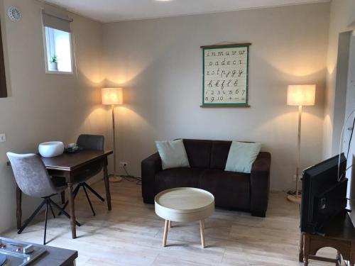 a living room with a couch and a table at t Schooltje in Schoondijke