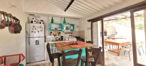a kitchen with a refrigerator and a table with chairs at La Rosaleda 1 - Hermosa finca en Paipa in Paipa
