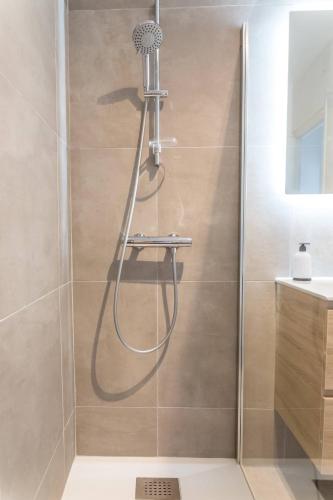 une douche avec pommeau de douche dans une salle de bain dans l'établissement @ Comme chez vous @ Proche gare et centre historique, à Brive-la-Gaillarde