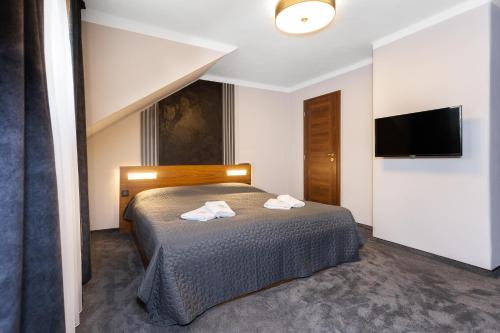a bedroom with a bed and a flat screen tv at GARDEN Restaurant & Pension in Pardubice