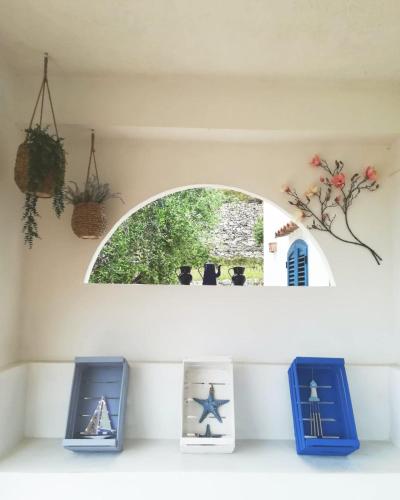 a shelf with three figurines in front of a window at Dimora Mediterranea in Mattinata