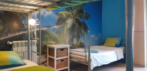 een slaapkamer met 2 bedden en een muurschildering van palmbomen bij Amazigh Guincho Hostel & Suites in Cascais