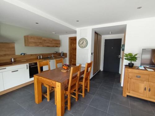 une cuisine avec une table en bois et quelques chaises dans l'établissement Les rives de la jamagne, à Gérardmer