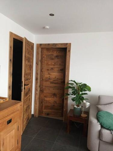 Cette chambre dispose d'une porte en bois et d'une plante en pot. dans l'établissement Les rives de la jamagne, à Gérardmer