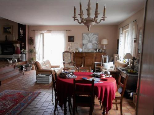 un salon avec une table et un tissu de table rouge dans l'établissement Chez Huguette, à Profondeville
