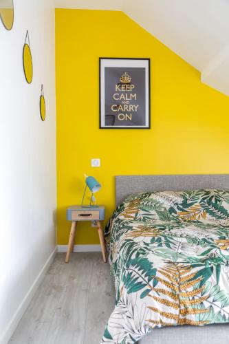 - une chambre avec un lit et un mur jaune dans l'établissement @ LOFT COCOONING @ Proche gare & centre historique, à Brive-la-Gaillarde