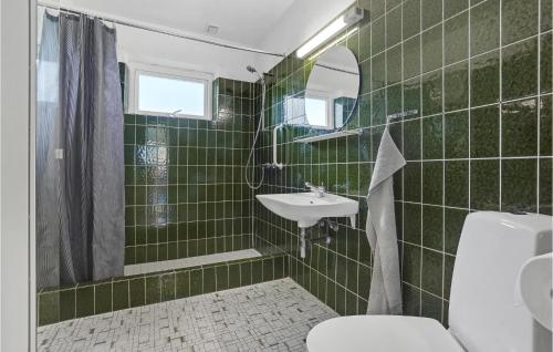 a green tiled bathroom with a toilet and a sink at Stunning Home In Sydals With Wifi in Skovby