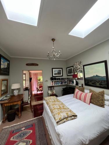 a bedroom with a large white bed and a desk at Constantia Guest House in Cape Town
