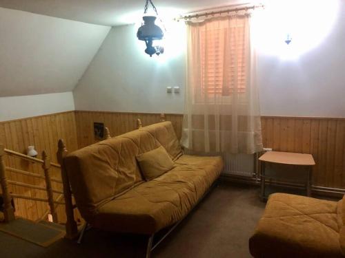 ein Wohnzimmer mit einem Sofa und einem Fenster in der Unterkunft Sugas Villa in Sfântu Gheorghe