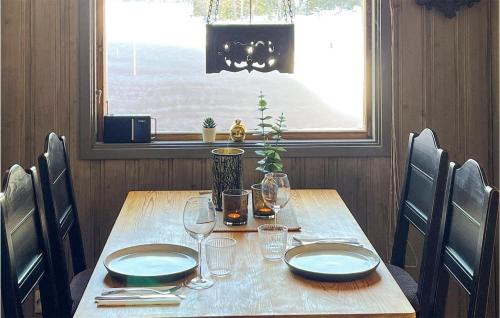 a wooden table with plates and wine glasses on it at 4 Bedroom Beautiful Home In Snertingdal 