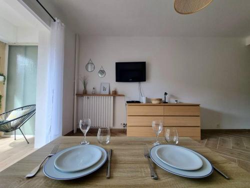 - une table avec deux assiettes et des verres à vin dans l'établissement Les studios d'Aurélia - Grand Théâtre de Provence, à Aix-en-Provence