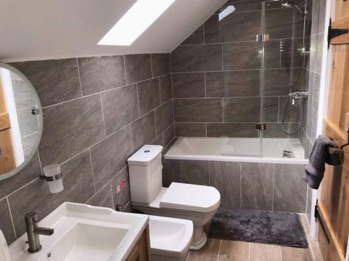 a bathroom with a toilet and a tub and a sink at 2 Bed Chic Peak District Cottage Barn Near Alton Towers, Polar Bears, Chatsworth House in Leek