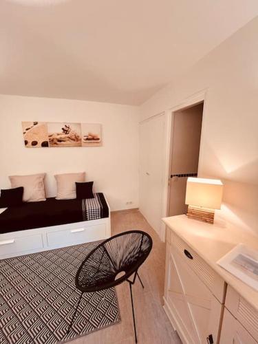 a bedroom with a bed with a desk and a chair at Studio jardin privatif 300m de la plage in Sainte-Maxime