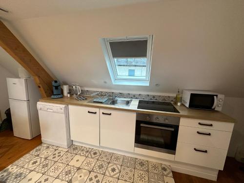 a small kitchen with a sink and a microwave at Superbe appartement proche centre ville, thermes in Bagnères-de-Bigorre