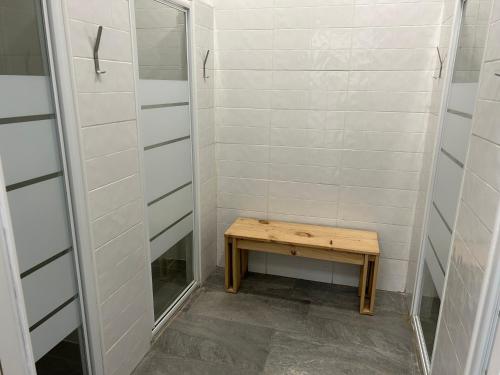 a walk in shower with a wooden table and a mirror at Albergue SCQ in Santiago de Compostela