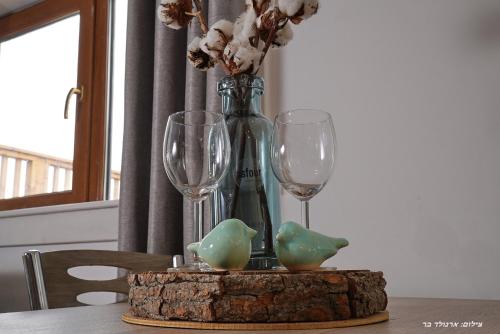 a table with two wine glasses and a vase at Suites Tuia in Had Nes
