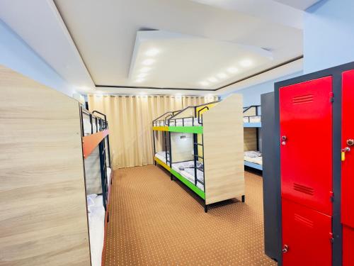 a room with two bunk beds and red doors at The Top Hostel in Tashkent