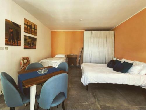 Cette chambre d'hôtel comprend deux lits, une table et des chaises. dans l'établissement Malta Suites, à Isla