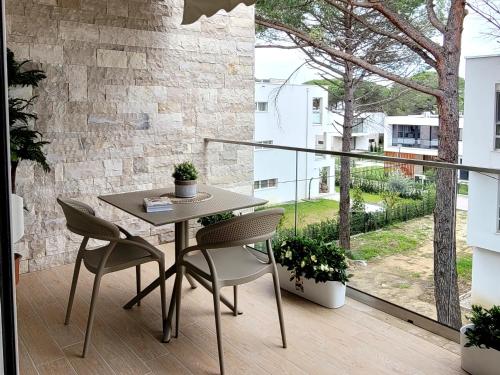 a table and chairs on a balcony with a large window at Evergreen Apartment San Pietro in Durrës