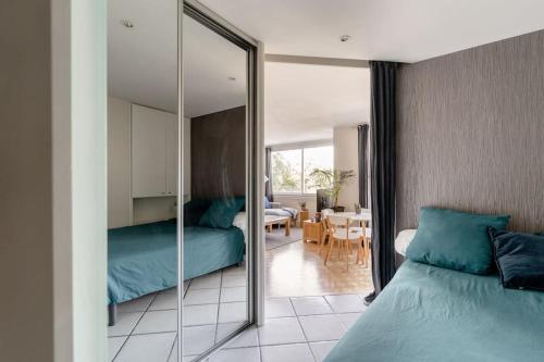 - une chambre avec un miroir, un lit et une salle à manger dans l'établissement Le Panorama - Vue Lac et Montagne avec parking, à Annecy