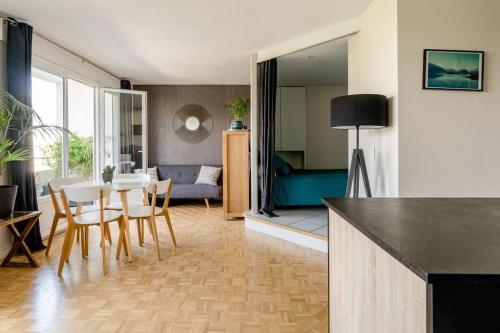 une cuisine et un salon avec une table et des chaises dans l'établissement Le Panorama - Vue Lac et Montagne avec parking, à Annecy