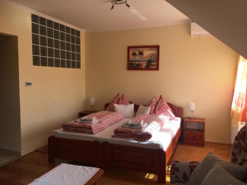 a room with a bed with two pillows on it at Jázmin Apartman in Harkány