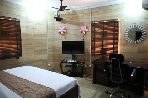 a bedroom with a desk and a computer with pink balloons at HPLagos BT in Lagos